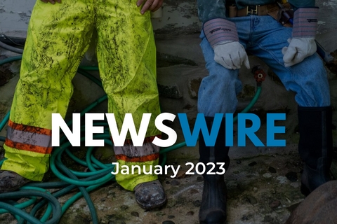 [ai] Two individuals sitting side by side on a surface with green garden hoses nearby. One person wears bright yellow waterproof pants and rubber boots, while the other is in blue jeans and black boots, both with gloves on.